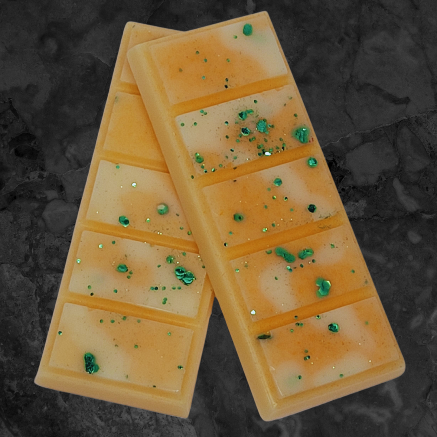 Brazilian Bum Bum Type soy wax snap bar melt. Orange and cream coloured wax with green bio glitter throughout.